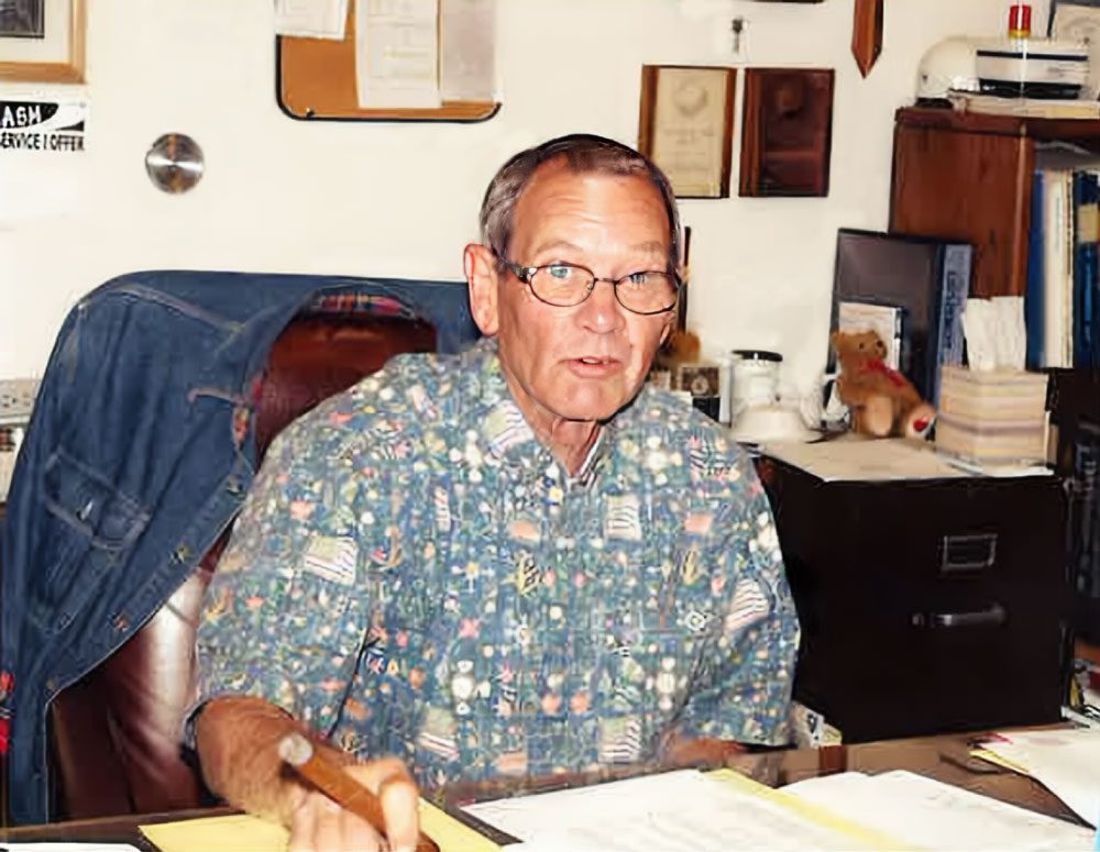 Joe Lomax portrait sitting at desk in Austin Hardwoods